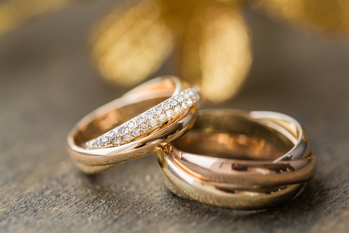 Two gold and diamond wedding rings sitting on top of each other. Image is used to describe a wedding content creator package and pricing for a 10 hour day.